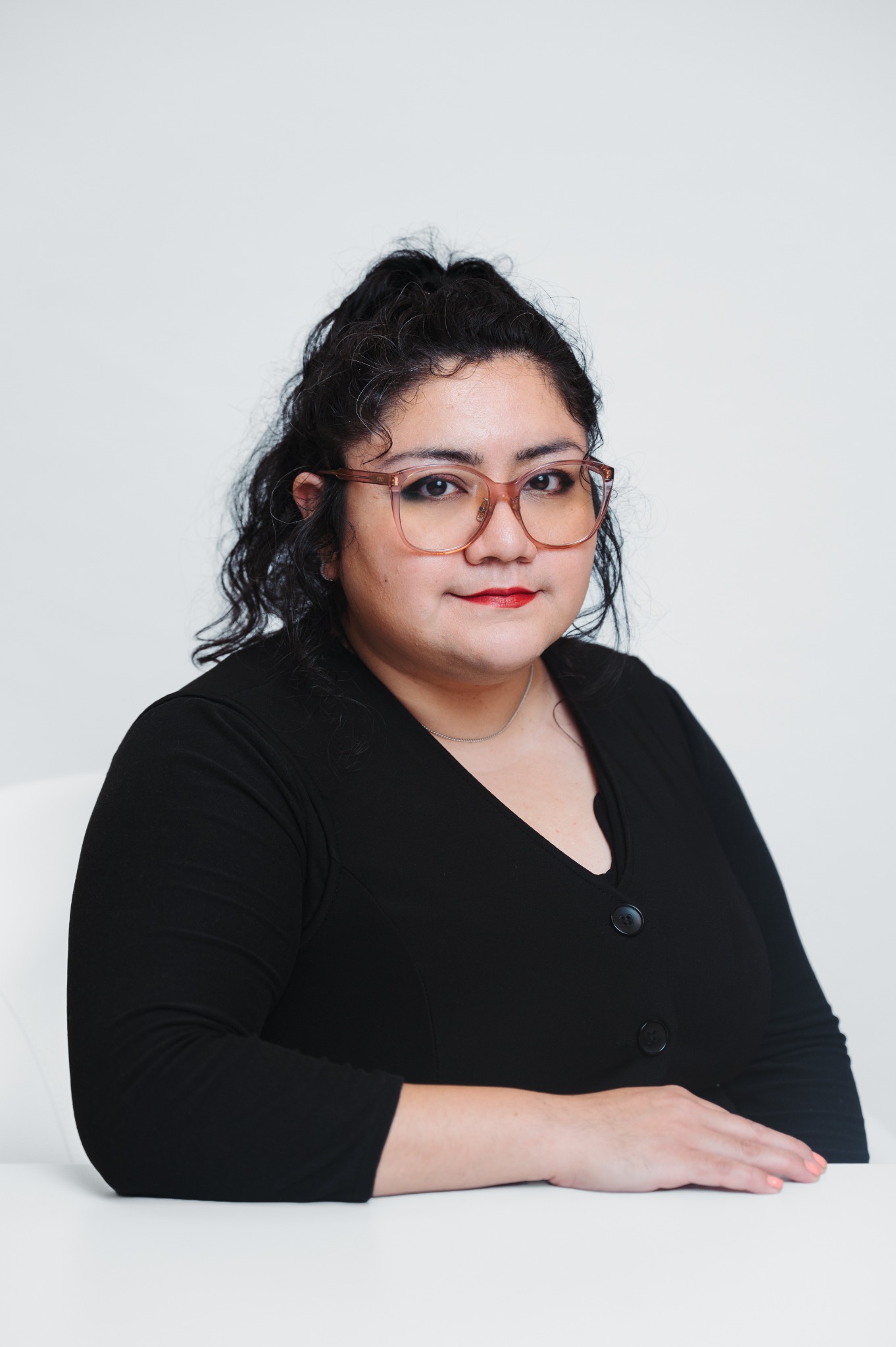 Denyse Clara wearing glasses and a black blazer